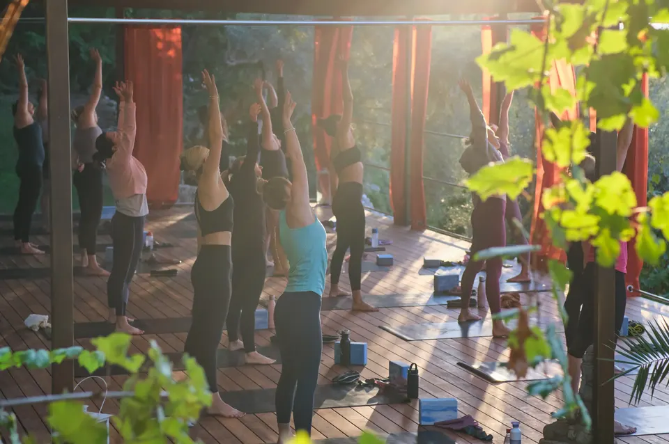 A yoga class in the shala, arms raised