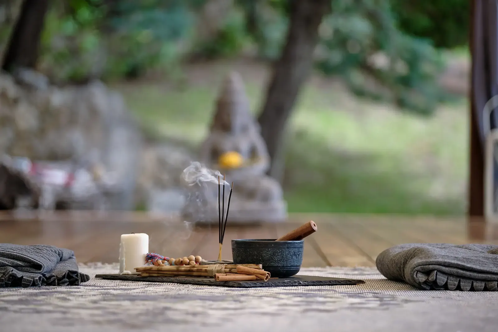 A Buddha statue and incense on the shala floor